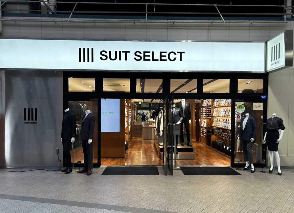 スーツセレクトビーンズ赤羽店頭。メンズ・レディース2台ずつのマネキンがトレンドのコーディネートを紹介しています。